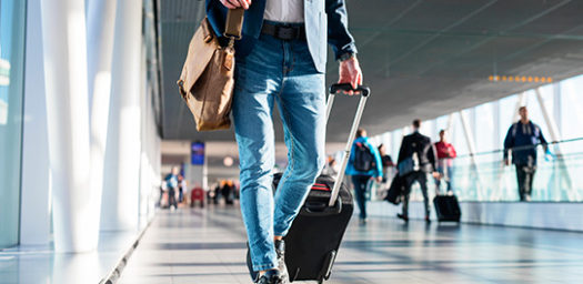 Viajero con maleta caminando por el aeropuerto