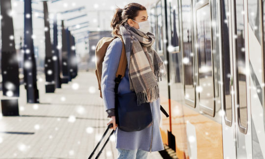 Mujer con mascarilla esperando para acceder a un tren