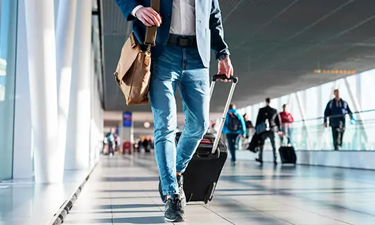 Viajero con maleta caminando por el aeropuerto