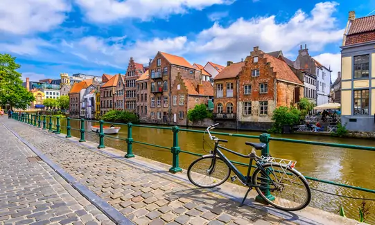 View of embankment of Leie river in the historic city center in Ghent (Gent), Belgium. Architecture and landmark of Ghent. Sunset cityscape of Ghent.
